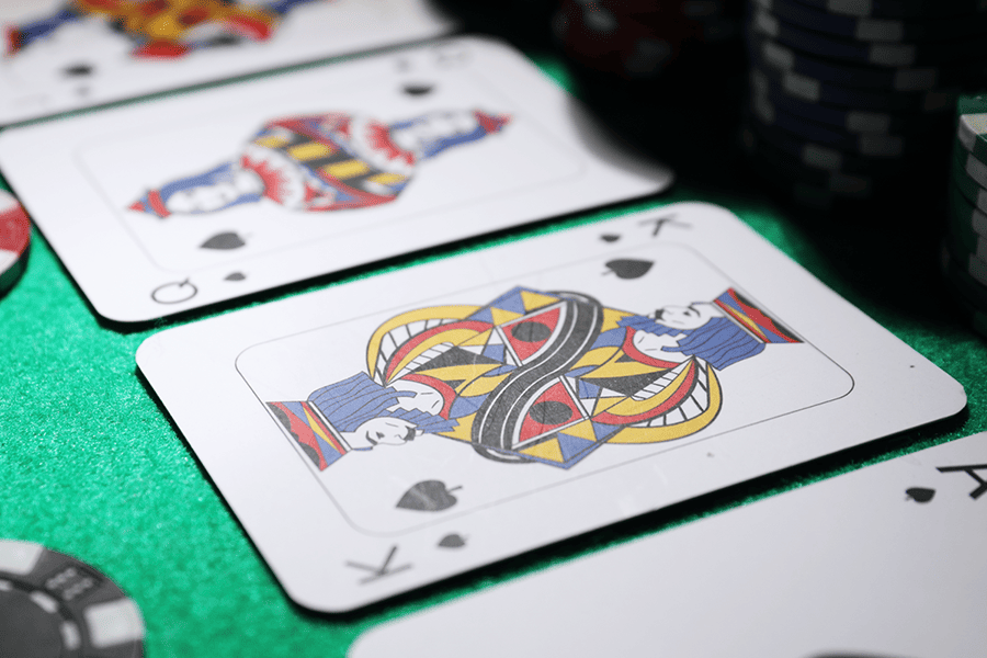Close-up of blackjack playing cards including a King and 8 of spades face-down on green casino felt with colorful chips – blackjack card values and hand rules